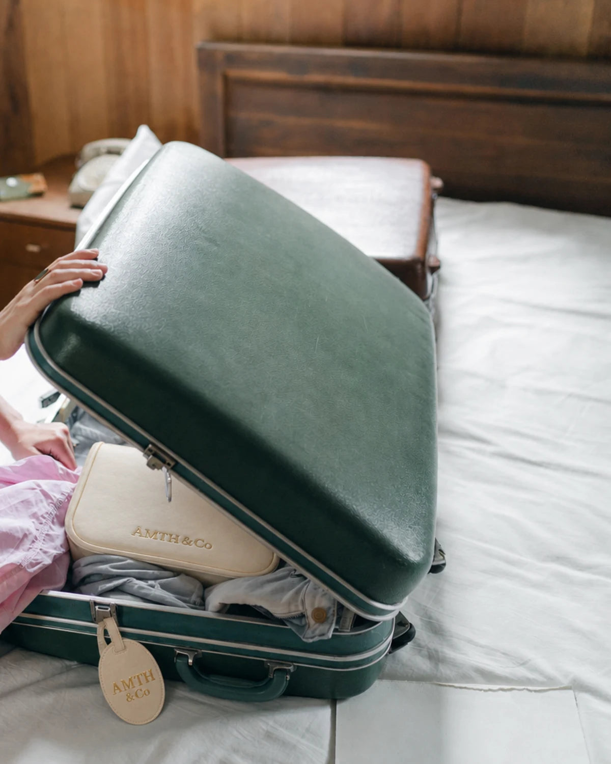 Open suitcase packed with AMTH & Co travel essentials